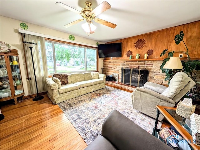 328 W Prentiss Ave, Findlay, OH 45840 - living room featuring a ceiling fan, a stone fireplace, wood-type flooring, and wooden walls