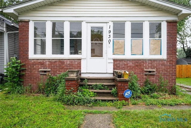 1930 Berkshire Pl, Toledo, OH 43613 - view of front facade with brick siding, crawl space, entry steps, and a sunroom