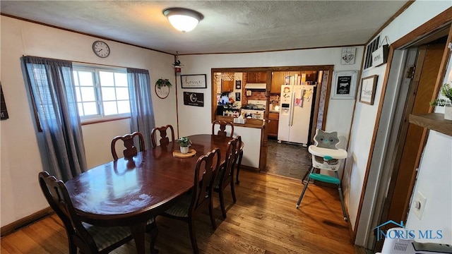 403 W Chestnut St, Wauseon, OH 43567 - dining room with dark wood-style floors, crown molding, and a textured ceiling