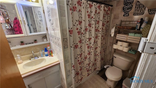 403 W Chestnut St, Wauseon, OH 43567 - bathroom with tile walls, vanity, and a shower with shower curtain