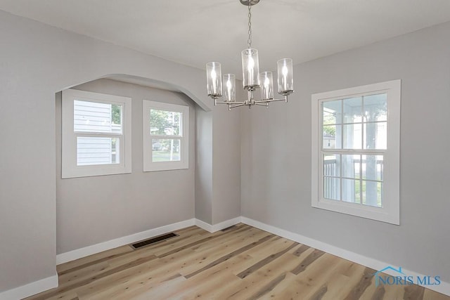 2242 Vaness Dr, Toledo, OH 43615 - unfurnished room with a chandelier, light wood-type flooring, and arched walkways