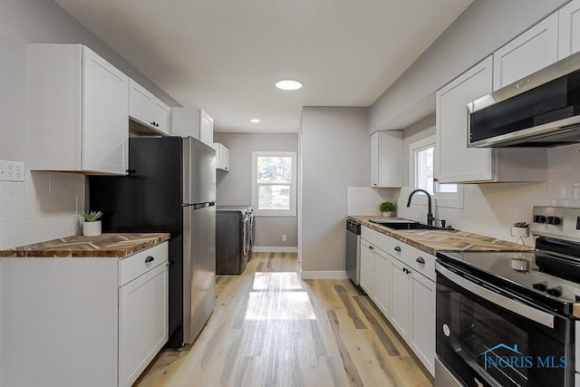 2242 Vaness Dr, Toledo, OH 43615 - kitchen with stainless steel appliances, light wood-style flooring, white cabinets, tasteful backsplash, and recessed lighting