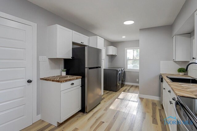 2242 Vaness Dr, Toledo, OH 43615 - kitchen with independent washer and dryer, appliances with stainless steel finishes, decorative backsplash, light wood-style floors, and recessed lighting