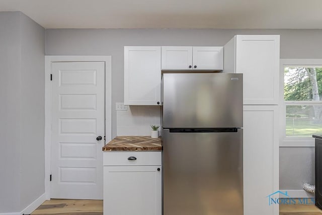 2242 Vaness Dr, Toledo, OH 43615 - kitchen with freestanding refrigerator, white cabinets, light wood finished floors, tasteful backsplash, and butcher block countertops
