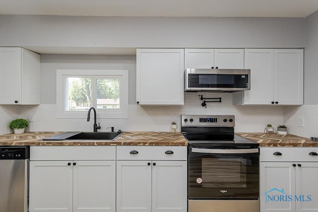 2242 Vaness Dr, Toledo, OH 43615 - kitchen featuring appliances with stainless steel finishes, wooden counters, and white cabinetry