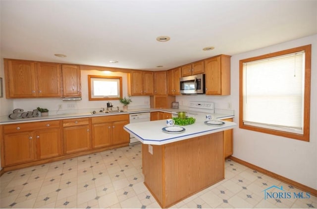 404 E Garfield Ave, Swanton, OH 43558 - kitchen featuring white appliances, light countertops, healthy amount of natural light, brown cabinetry, and recessed lighting