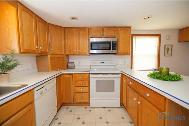 404 E Garfield Ave, Swanton, OH 43558 - kitchen with white appliances, light countertops, and brown cabinets