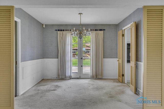 3733 Shamrock Dr, Toledo, OH 43615 - unfurnished dining area with wallpapered walls, a chandelier, wainscoting, carpet, and french doors