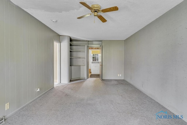 3733 Shamrock Dr, Toledo, OH 43615 - carpeted spare room featuring ceiling fan, a textured ceiling, and wood walls