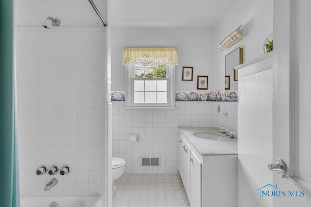 3733 Shamrock Dr, Toledo, OH 43615 - bathroom with vanity, shower / bathtub combination, tile walls, and a wainscoted wall