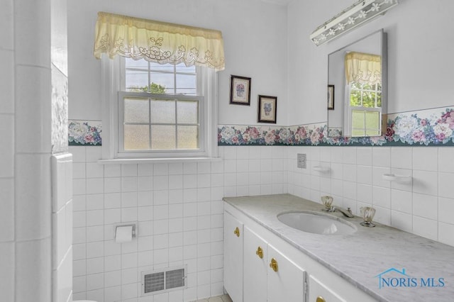 3733 Shamrock Dr, Toledo, OH 43615 - bathroom featuring vanity, plenty of natural light, a wainscoted wall, and tile walls