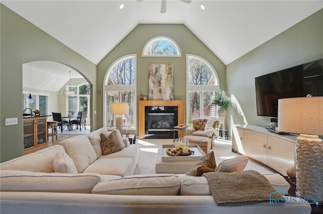 3862 Ravine Hollow Ct, Maumee, OH 43537 - living room with a ceiling fan, high vaulted ceiling, arched walkways, and a glass covered fireplace