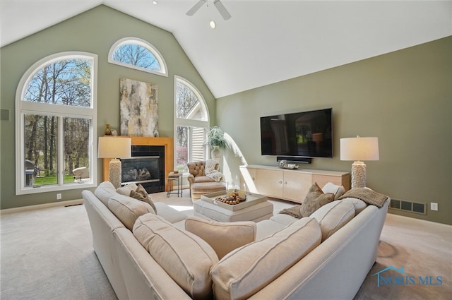 3862 Ravine Hollow Ct, Maumee, OH 43537 - carpeted living room featuring high vaulted ceiling, a ceiling fan, and a glass covered fireplace