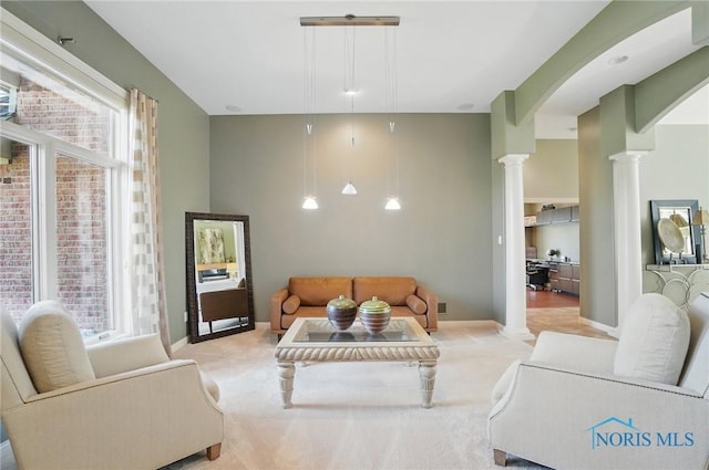 3862 Ravine Hollow Ct, Maumee, OH 43537 - living area featuring decorative columns, light carpet, and arched walkways