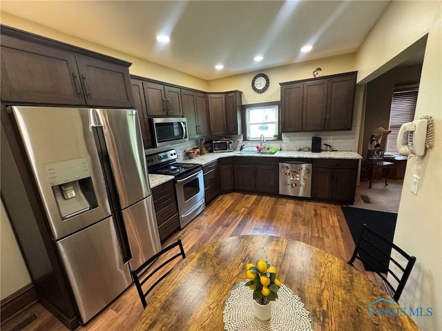 506 Ditto St, Archbold, OH 43502 - kitchen featuring appliances with stainless steel finishes, dark brown cabinets, dark wood-type flooring, tasteful backsplash, and recessed lighting