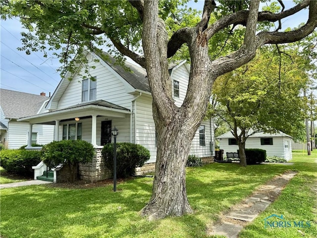 716 Davidson St, Defiance, OH 43512 - view of front facade featuring a front yard, covered porch, and a shingled roof
