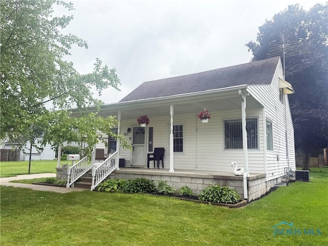 703 College Ave, Fostoria, OH 44830 - view of front of home with a porch, a front lawn, and roof with shingles