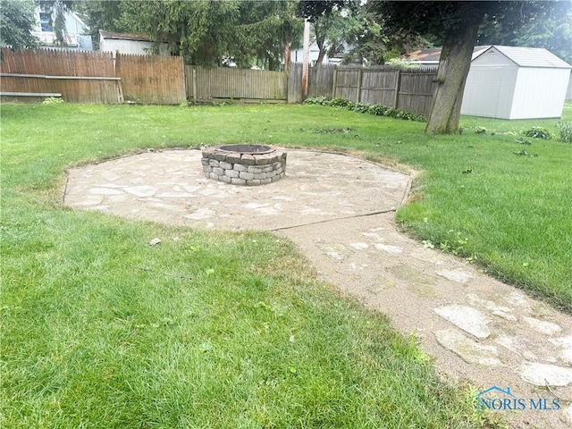 703 College Ave, Fostoria, OH 44830 - fenced backyard with an outdoor fire pit, a shed, and a patio
