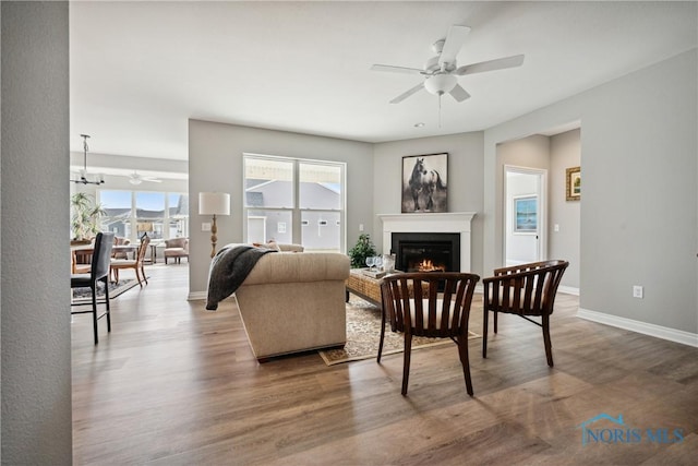 3343 Moonlit Pass, Monclova, OH 43542 - living area featuring a ceiling fan, a glass covered fireplace, wood finished floors, and a chandelier