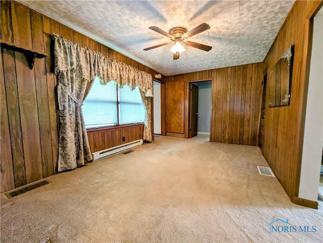 6151 The Bend Rd, Ney, OH 43549 - empty room featuring baseboard heating, wooden walls, a ceiling fan, and light carpet