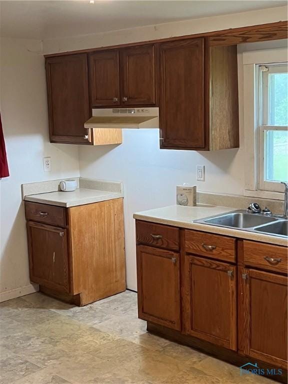 643 N 5th St, Fremont, OH 43420 - kitchen with under cabinet range hood, light countertops, and stone finish floors