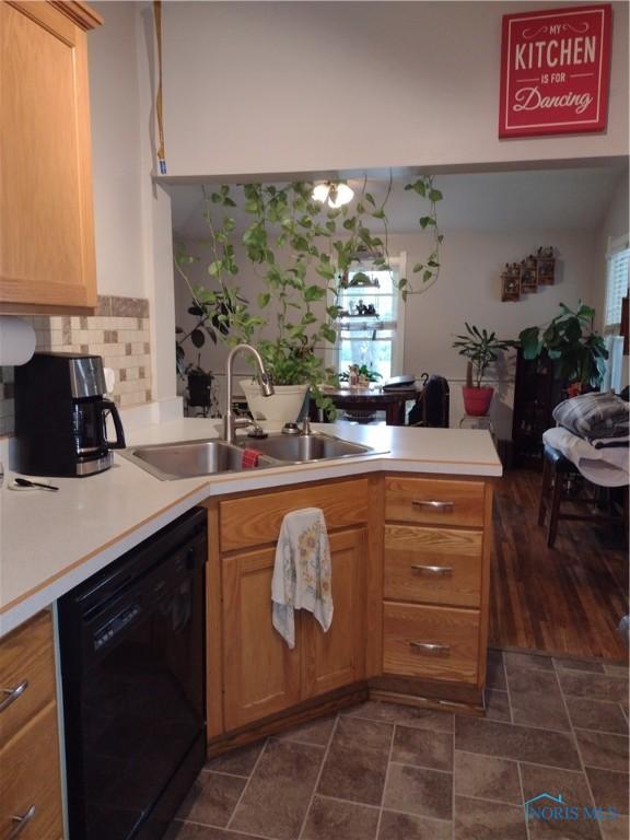 200 Pleasant St, Archbold, OH 43502 - kitchen with black dishwasher, stone finish floors, a peninsula, backsplash, and light countertops