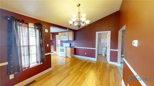 420 Ames St, Clyde, OH 43410 - unfurnished dining area with a chandelier, vaulted ceiling, healthy amount of natural light, and light wood-style flooring