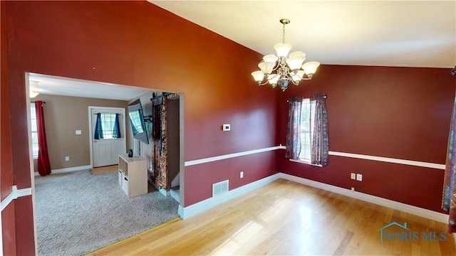 420 Ames St, Clyde, OH 43410 - unfurnished room featuring a chandelier, wood finished floors, and a barn door