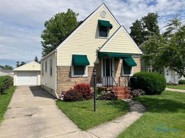4614 290th St, Toledo, OH 43611 - view of front of house featuring an outdoor structure, a front lawn, and a detached garage