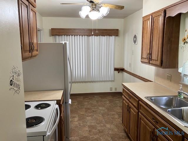 4614 290th St, Toledo, OH 43611 - kitchen with white electric range, ceiling fan, light countertops, and brown cabinets
