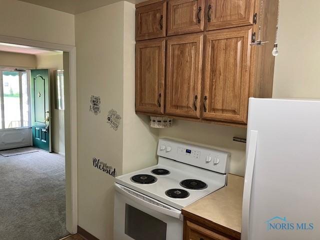 4614 290th St, Toledo, OH 43611 - kitchen with white appliances, carpet, light countertops, and brown cabinets