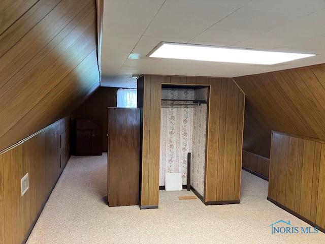 4614 290th St, Toledo, OH 43611 - additional living space with wood walls, lofted ceiling, and light carpet