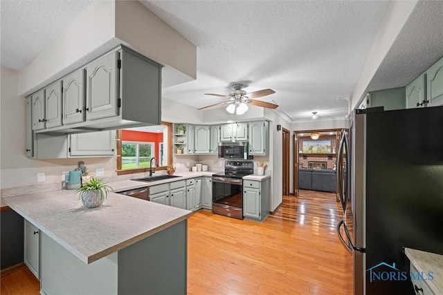 15180 Dirlam Rd, Bowling Green, OH 43402 - kitchen featuring stainless steel appliances, a peninsula, healthy amount of natural light, a ceiling fan, and a textured ceiling