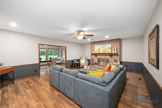 15180 Dirlam Rd, Bowling Green, OH 43402 - living room featuring a wainscoted wall, wood finished floors, a ceiling fan, a fireplace, and recessed lighting