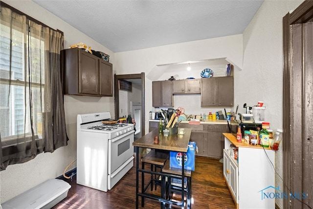 743 Clark St, Toledo, OH 43605 - kitchen featuring white gas range, dark wood-type flooring, light countertops, dark brown cabinetry, and a textured wall