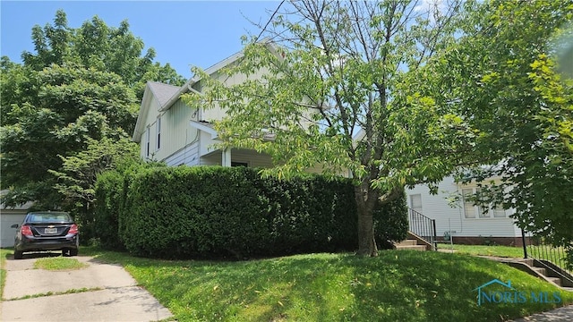 4024 Commonwealth Ave, Toledo, OH 43612 - view of home's exterior with board and batten siding, a lawn, and concrete driveway