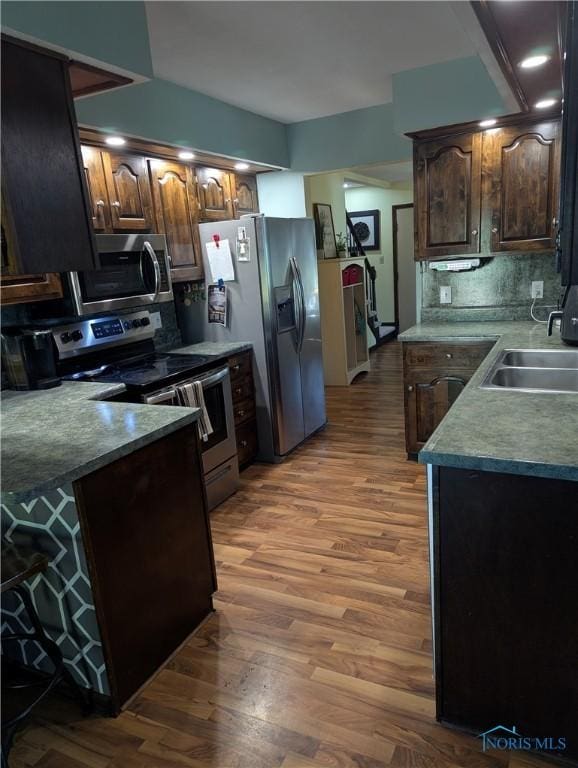 16020 County Road D, Wauseon, OH 43567 - kitchen featuring stainless steel appliances, wood finished floors, backsplash, and dark brown cabinets