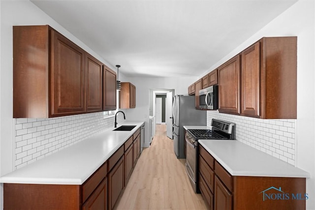 2521 Shallowford Dr, Toledo, OH 43611 - kitchen with appliances with stainless steel finishes, light wood-style flooring, tasteful backsplash, and light countertops