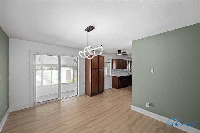 2521 Shallowford Dr, Toledo, OH 43611 - unfurnished dining area with light wood-style flooring, healthy amount of natural light, ceiling fan, and a chandelier