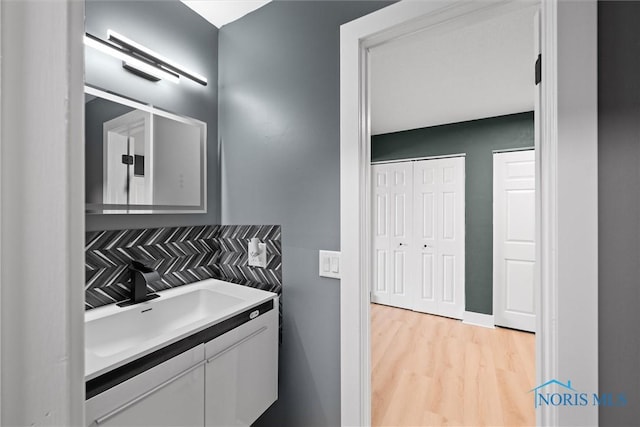 2521 Shallowford Dr, Toledo, OH 43611 - bathroom featuring vanity, wood finished floors, and tasteful backsplash