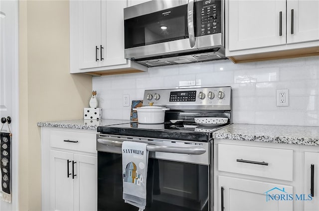 5352 Brint Crossing Blvd, Sylvania, OH 43560 - kitchen featuring appliances with stainless steel finishes, decorative backsplash, white cabinets, and light stone counters