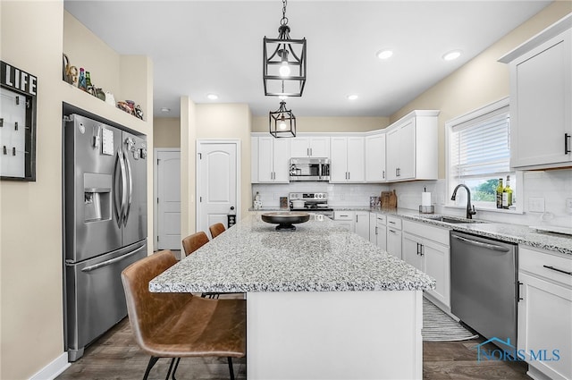 5352 Brint Crossing Blvd, Sylvania, OH 43560 - kitchen featuring stainless steel appliances, dark wood finished floors, a kitchen bar, decorative backsplash, and recessed lighting