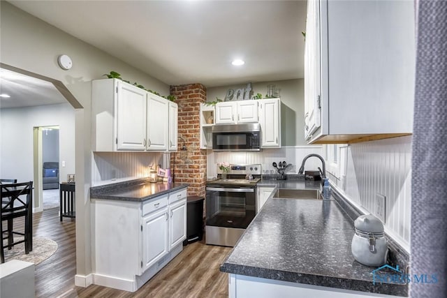 525 Western Ave, Findlay, OH 45840 - kitchen with appliances with stainless steel finishes, dark countertops, white cabinets, wood finished floors, and recessed lighting