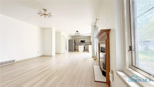 1303 Finch Dr, Bowling Green, OH 43402 - unfurnished living room featuring light wood-style flooring and baseboards