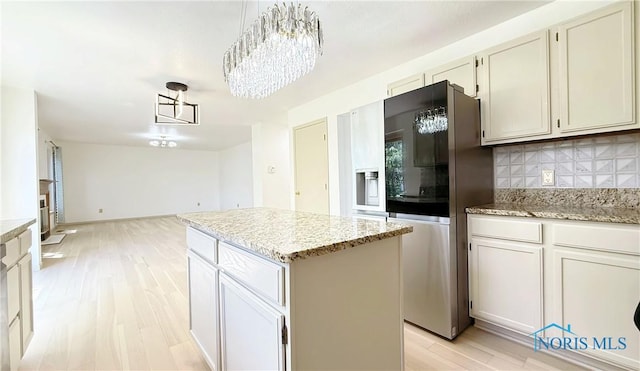 1303 Finch Dr, Bowling Green, OH 43402 - kitchen with stainless steel refrigerator with ice dispenser, tasteful backsplash, light wood finished floors, a chandelier, and a center island