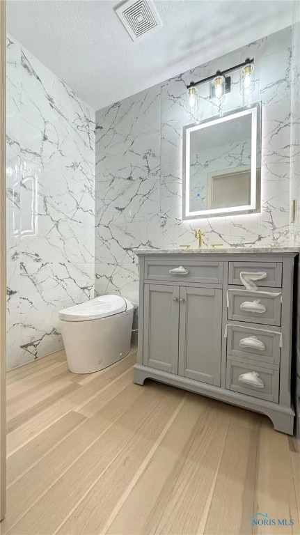 1303 Finch Dr, Bowling Green, OH 43402 - bathroom featuring vanity, wood finished floors, and a textured ceiling
