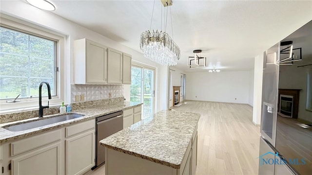 1303 Finch Dr, Bowling Green, OH 43402 - kitchen featuring stainless steel dishwasher, a chandelier, light wood-style flooring, and light stone countertops