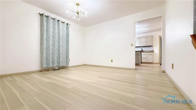 1303 Finch Dr, Bowling Green, OH 43402 - empty room featuring light wood-type flooring and a chandelier