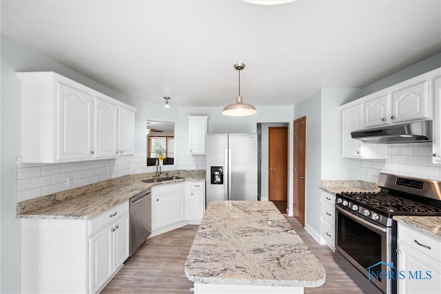 1528 Indian Creek Dr, Perrysburg, OH 43551 - kitchen featuring under cabinet range hood, stainless steel appliances, tasteful backsplash, and a center island
