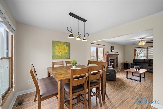 1528 Indian Creek Dr, Perrysburg, OH 43551 - dining space with light wood-style floors, a fireplace, and ceiling fan